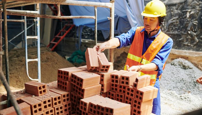 Builder taking orange bricks