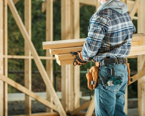 Construction Worker Moving Wood Material